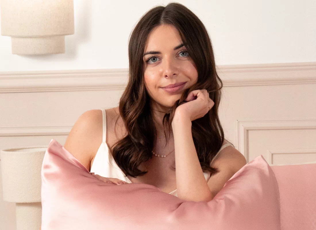 Femme assise avec un coussin en soie rose