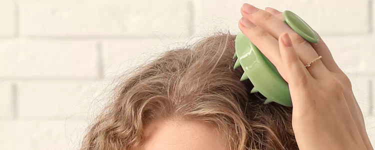 Massage du cuir chevelu avec une brosse à picots pour stimuler la pousse des cheveux