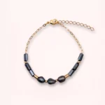 Vue complète du bracelet Auréa avec chaîne en or laminé, perles de culture bleu marine et perles de verre de Bohême sur fond clair.