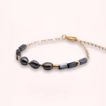 Bracelet Auréa en or laminé 14 carats, avec perles de culture bleu marine et perles de Bohême, présenté à plat sur fond clair.