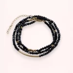 Bracelet collier Nocturne 2-en-1 en perles de verre de Bohême bleu marine et or laminé 14 carats, présenté en plusieurs rangs sur fond clair.