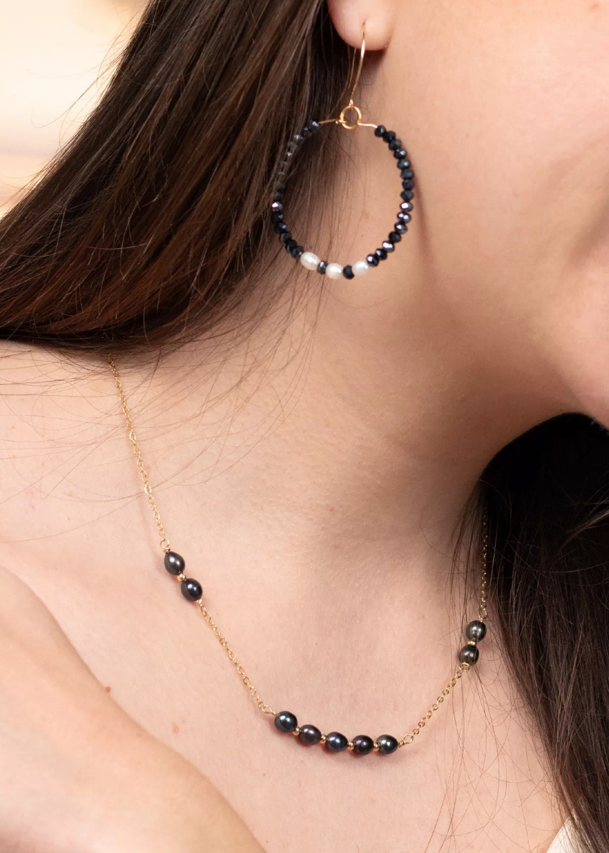 Collier Nérée en plaqué or et perles de culture bleu marine porté autour du cou, associé aux créoles Éclat assorties.