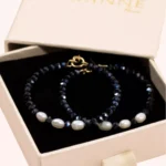 Paire de créoles Éclat en perles de Bohême bleu marine et perles de culture blanches, présentée dans une boîte cadeau GAÏANNE.