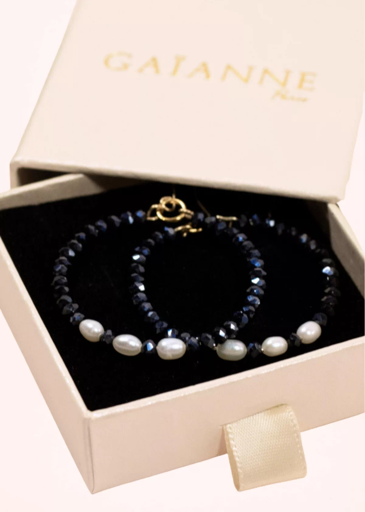 Paire de créoles Éclat en perles de Bohême bleu marine et perles de culture blanches, présentée dans une boîte cadeau GAÏANNE.