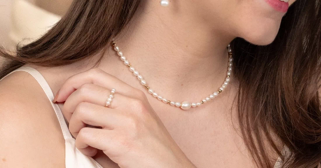 Femme portant des bijoux Gaïanne dorés et des perles