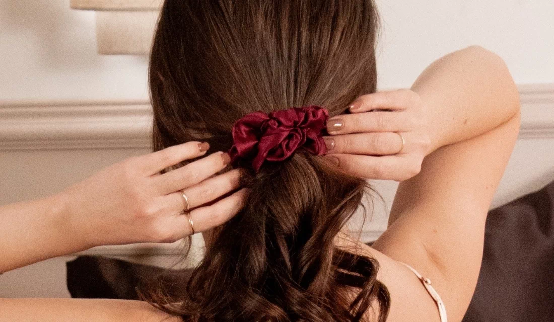 Femme attachant ses cheveux avec un chouchou en soie