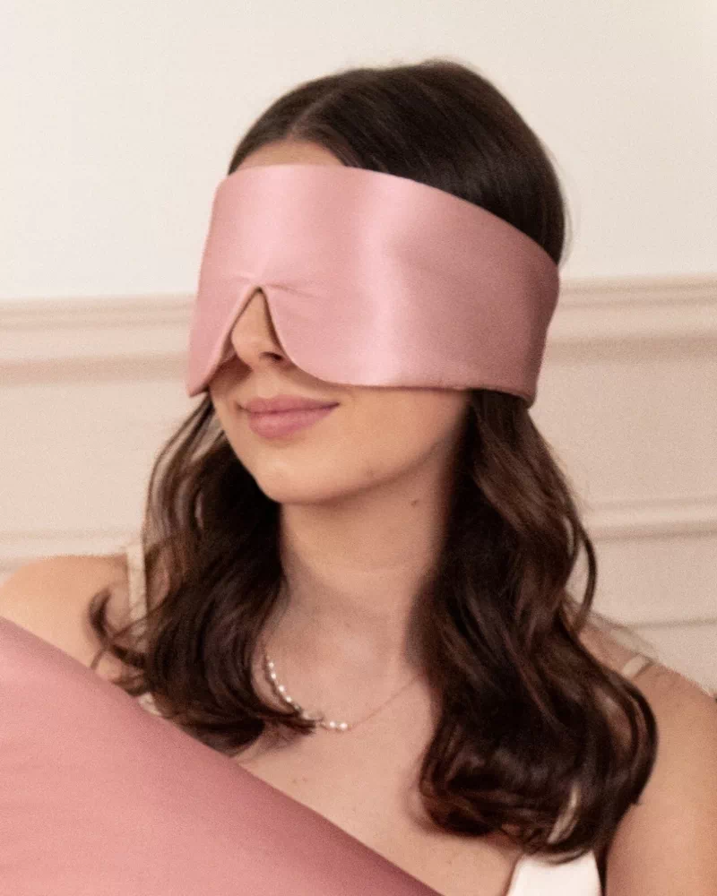 Femme portant un masque bandeau réglable en soie coloris Bois de rose