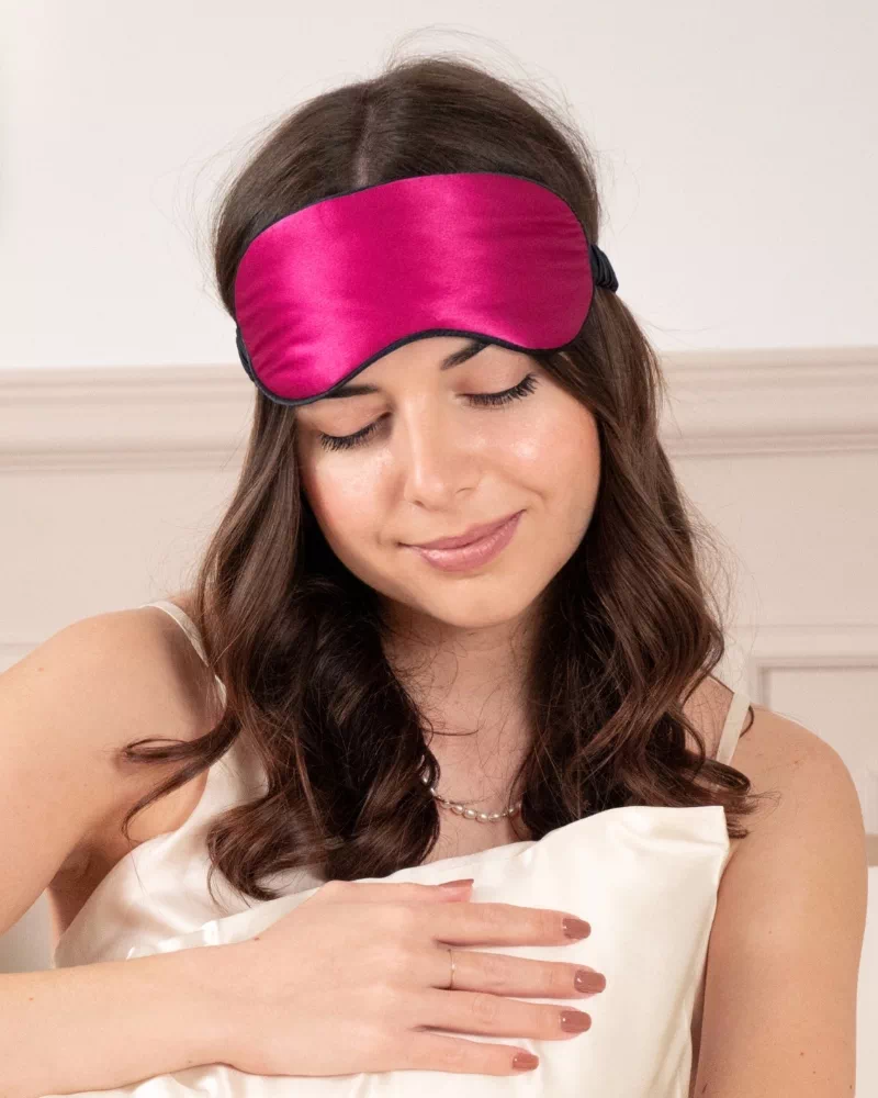 Femme portant un masque de nuit classique en soie coloris Fuchsia