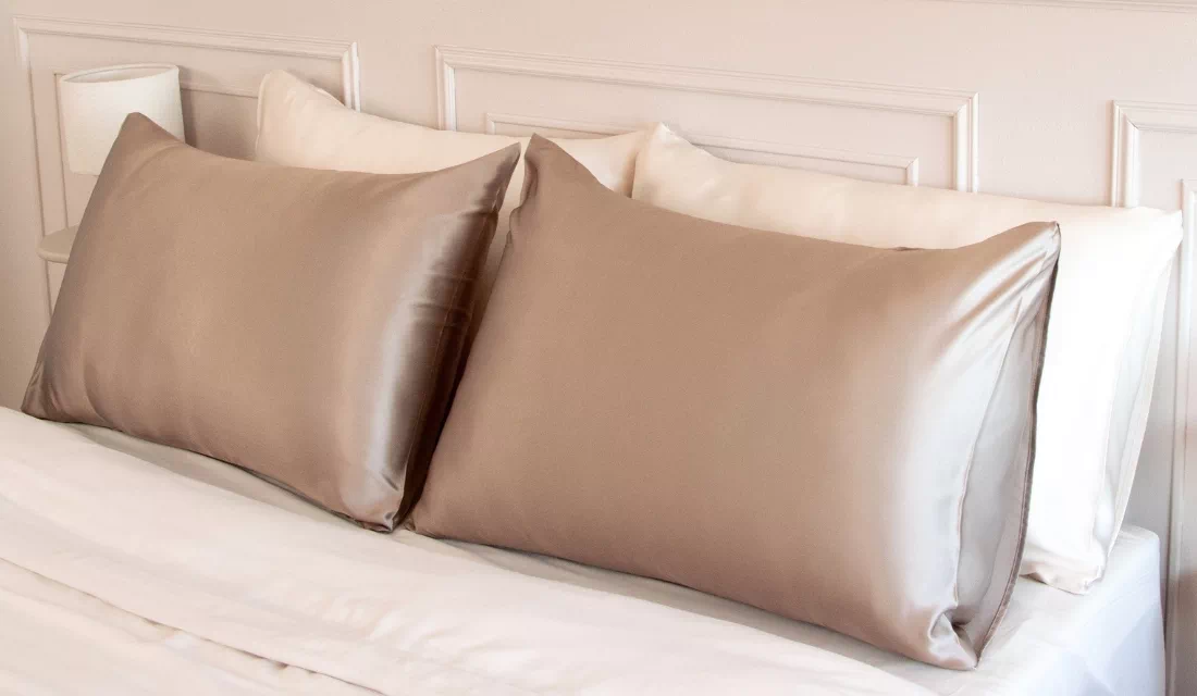 Taies d’oreiller en soie de mûrier coloris champagne sur un lit