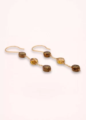 Boucles d'oreilles pendantes Nathéa en perles de verre de Bohême aux nuances miel, caramel et brun, avec chaînes fines dorées et attaches crochets, sur fond clair.