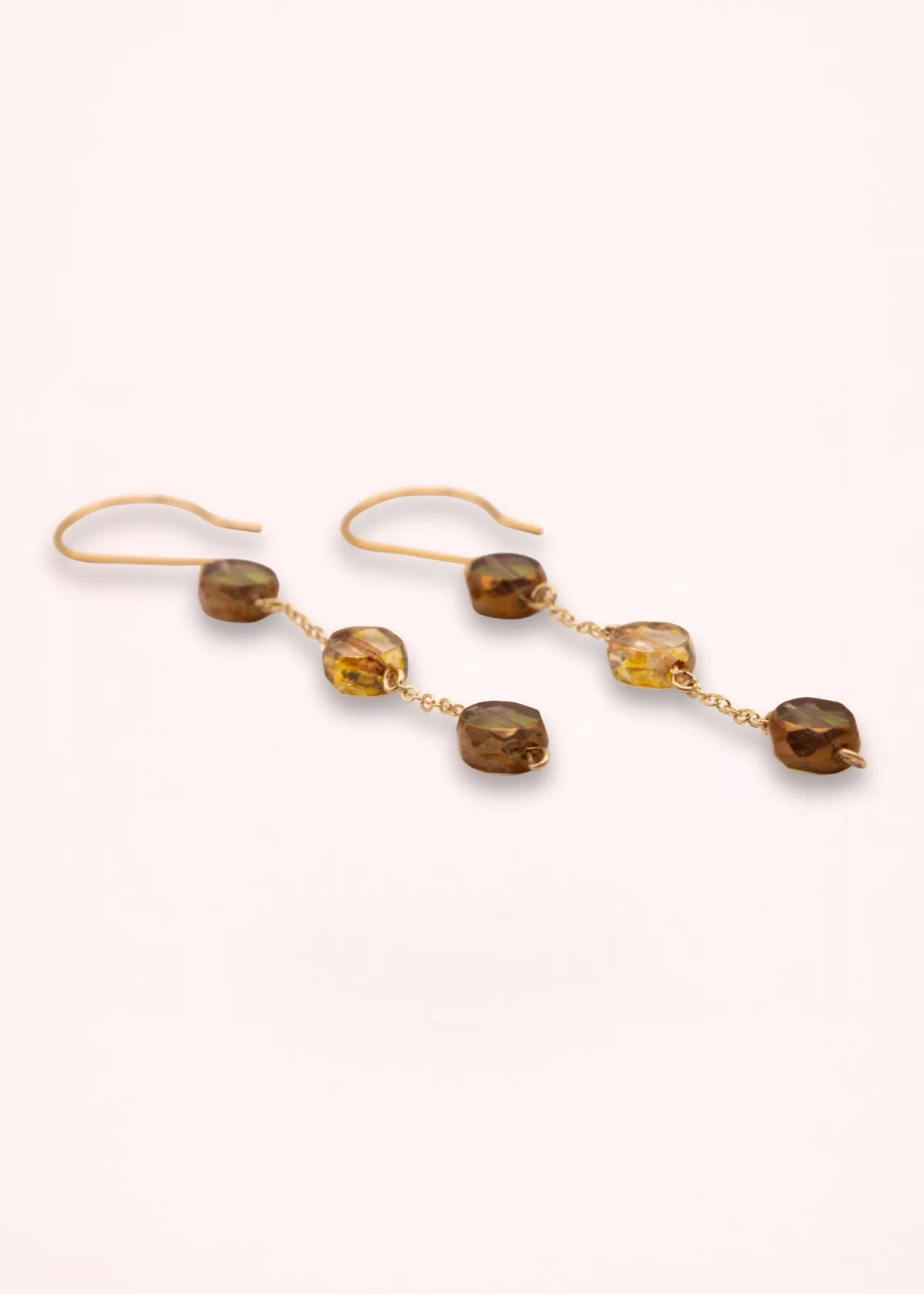 Boucles d'oreilles pendantes Nathéa en perles de verre de Bohême aux nuances miel, caramel et brun, avec chaînes fines dorées et attaches crochets, sur fond clair.