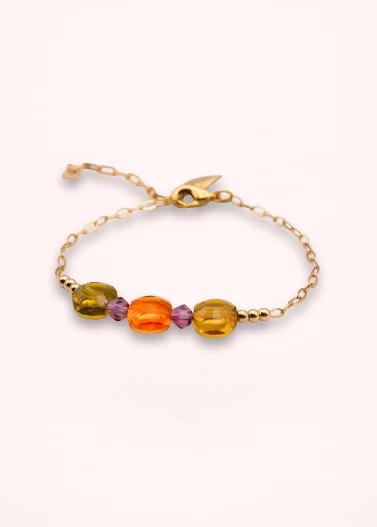 Vue rapprochée du bracelet Marélie montrant ses perles en verre de Bohême orange et jaune doré, sa chaîne fine en or laminé et son pendentif feuille dorée.