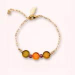 Bracelet Marélie en or laminé 14 carats avec perles de Bohême colorées aux tons orange et doré, et petite feuille dorée, sur fond clair.