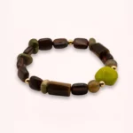 Bracelet Olia en pierres naturelles d'œil de tigre et d'unakite, avec une touche vert pomme en verre de Bohême et des détails en or laminé 14K, sur fond clair.