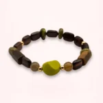 Vue de face du bracelet élastique Olia avec pierres naturelles brunes et vertes, touche vert pomme en verre de Bohême et détails dorés en or laminé.