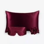 Coffret Les Essentiels Bandeau : taie d’oreiller, masque bandeau réglable et grand chouchou, tous en soie bordeaux.
