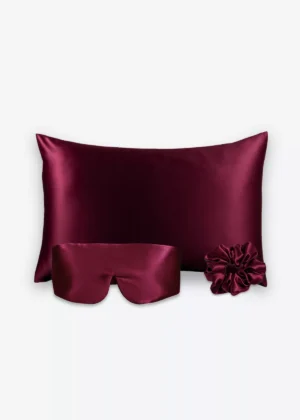Coffret Les Essentiels Bandeau : taie d’oreiller, masque bandeau réglable et grand chouchou, tous en soie bordeaux.