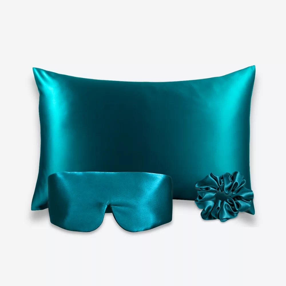 Coffret Les Essentiels Bandeau : taie d’oreiller, masque bandeau réglable et grand chouchou, tous en soie bleu canard.