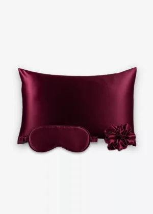 Coffret Les Essentiels : taie d’oreiller, masque de nuit classique et grand chouchou, tous en soie bordeaux.