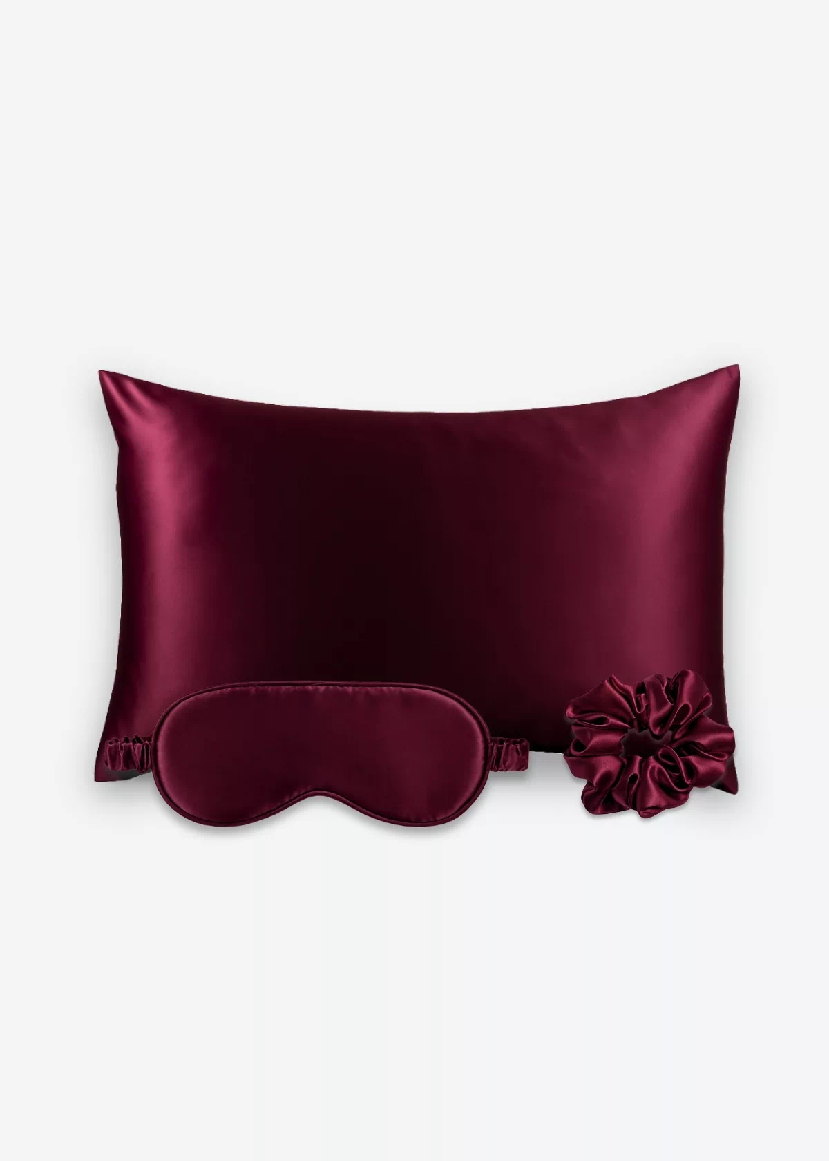 Coffret Les Essentiels : taie d’oreiller, masque de nuit classique et grand chouchou, tous en soie bordeaux.