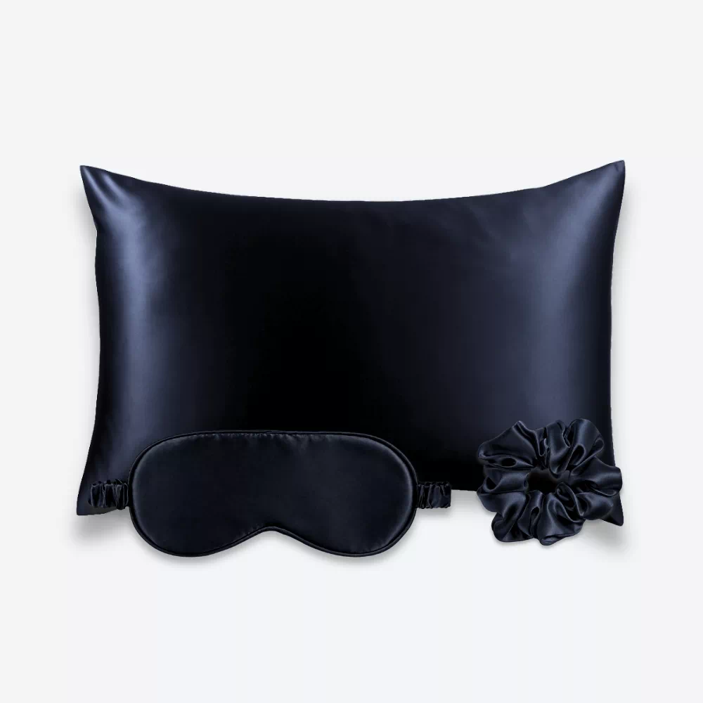 Coffret Les Essentiels : taie d’oreiller, masque de nuit classique et grand chouchou, tous en soie bleu nuit.