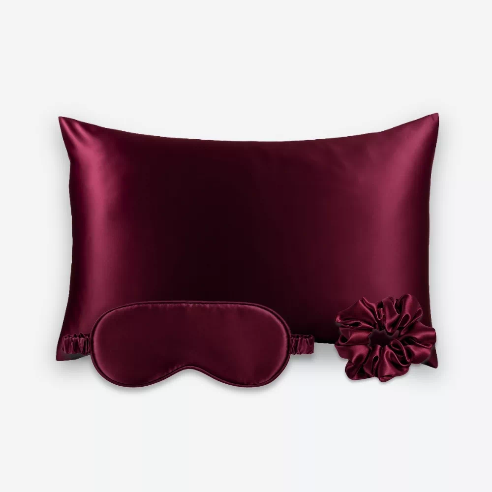 Coffret Les Essentiels : taie d’oreiller, masque de nuit classique et grand chouchou, tous en soie bordeaux.