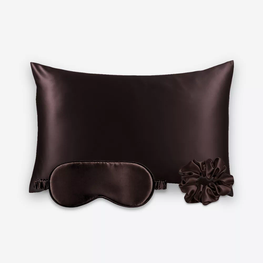 Coffret Les Essentiels : taie d’oreiller, masque de nuit classique et grand chouchou, tous en soie marron chocolat.