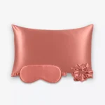 Coffret Les Essentiels : taie d’oreiller, masque de nuit classique et grand chouchou, tous en soie terracotta.