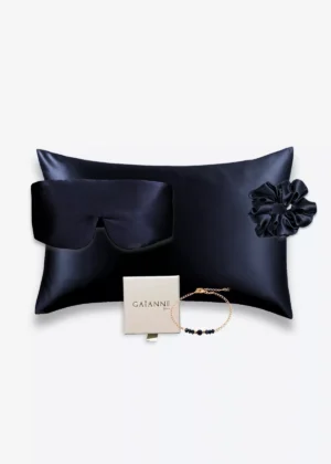 Coffret bleu nuit avec taie d’oreiller, masque bandeau et grand chouchou en soie, accompagné d’un bracelet bleu en or laminé 14k et perles.