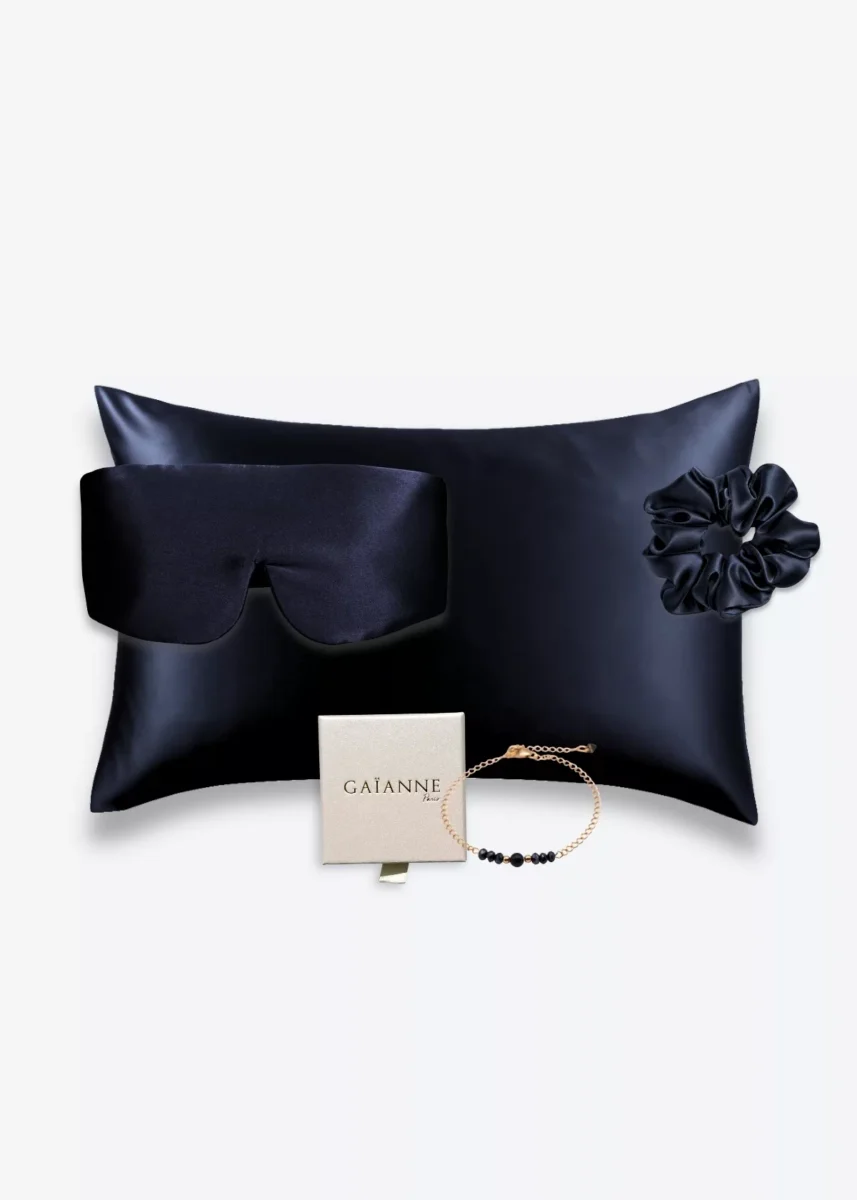 Coffret bleu nuit avec taie d’oreiller, masque bandeau et grand chouchou en soie, accompagné d’un bracelet bleu en or laminé 14k et perles.