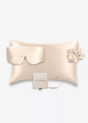Coffret champagne avec taie d’oreiller, masque bandeau et grand chouchou en soie, accompagné d’un bracelet champagne en or laminé 14k et perles d’eau douce.