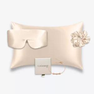 Coffret champagne avec taie d’oreiller, masque bandeau et grand chouchou en soie, accompagné d’un bracelet champagne en or laminé 14k et perles d’eau douce.