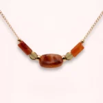 Collier Sienna en or laminé 14K avec perle centrale en verre de Bohême, pierres naturelles de cornaline orangées et détails dorés, sur fond clair.