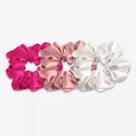 Trois grands chouchous en soie : un rose fuchsia, un bois de rose et un blanc crème.