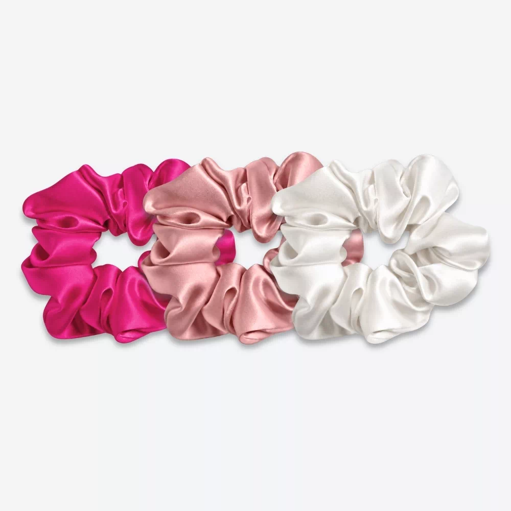 Trois grands chouchous en soie : un rose fuchsia, un bois de rose et un blanc crème.