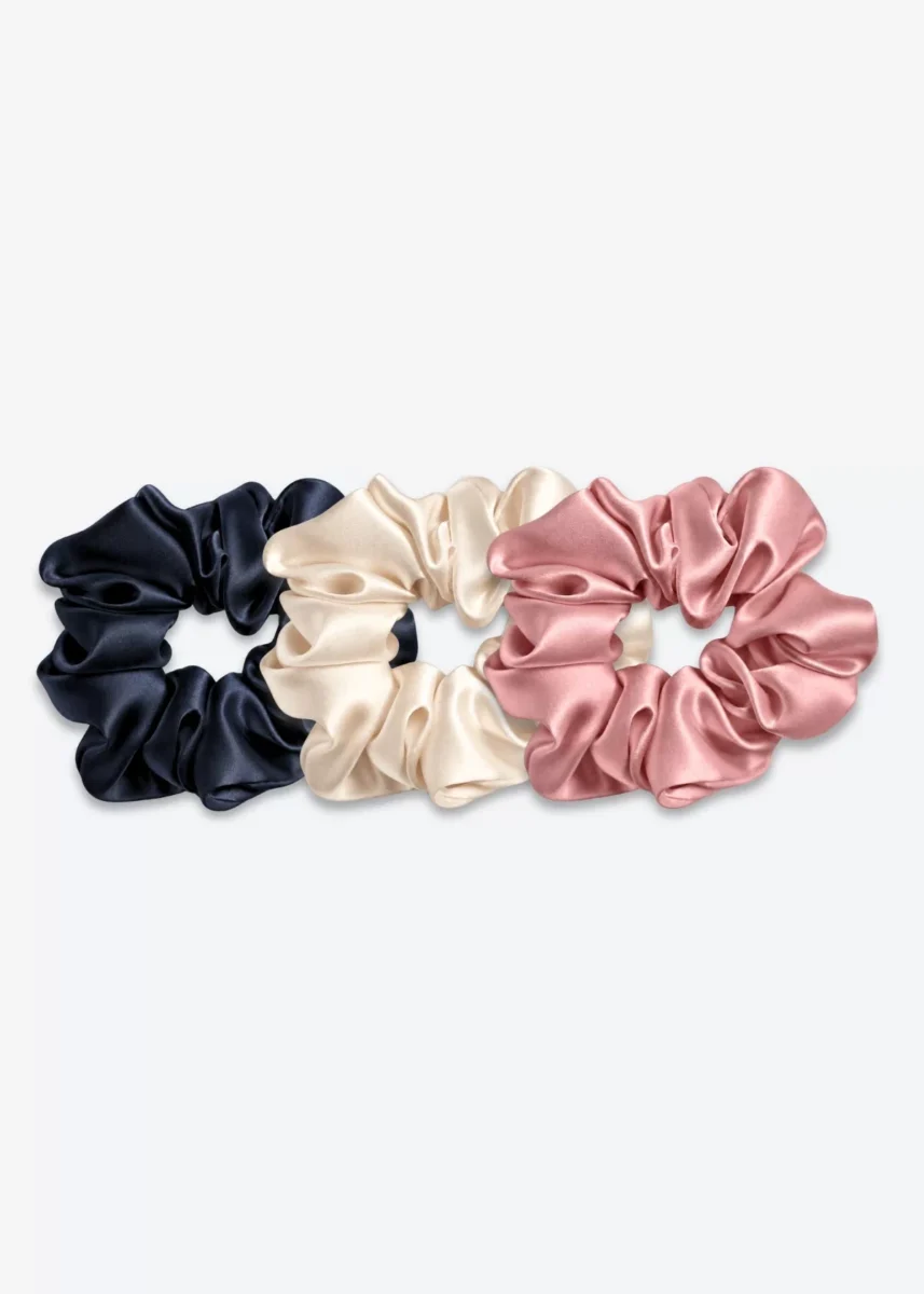 Trois grands chouchous en soie : un bleu nuit, un champagne et un bois de rose.