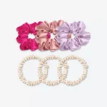 Trois grands chouchous en soie rose fuchsia, bois de rose et lilas, accompagnés de trois chouchous fins en soie champagne.